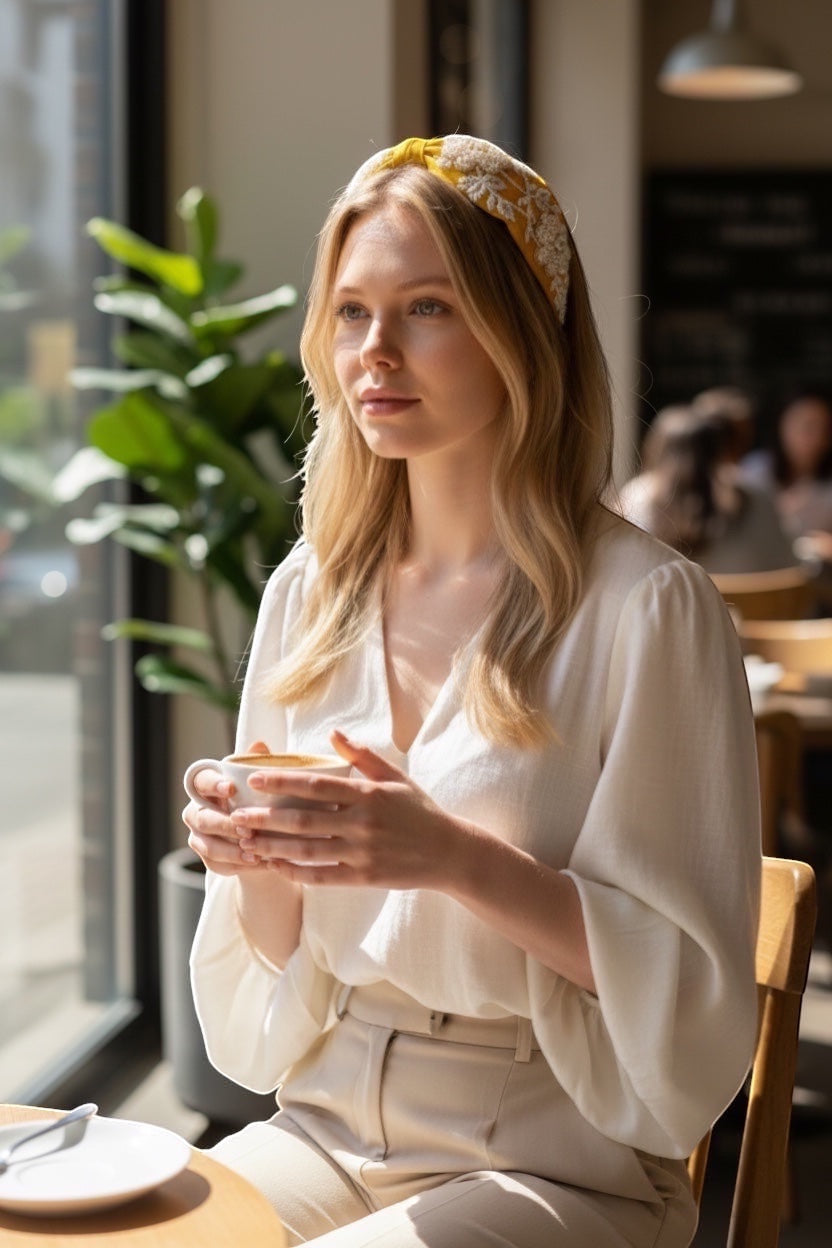 JOYCO Alessia yellow fabric headband with intricate white pearl and bead floral embroidery and gold accents.