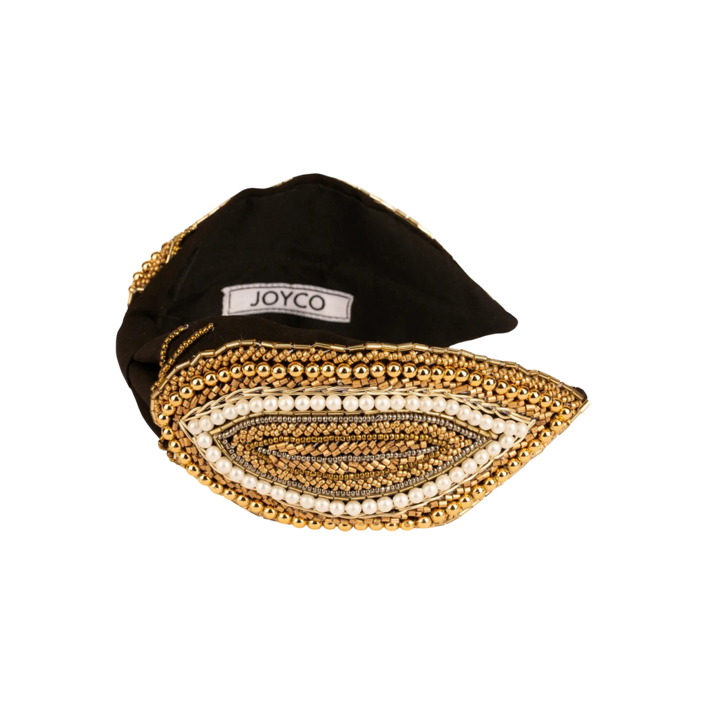 JOYCO black fabric headband with intricate gold bead and pearl embroidery in an eye shape.